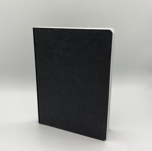 Black notebook with a visible brand logo on a light gray background