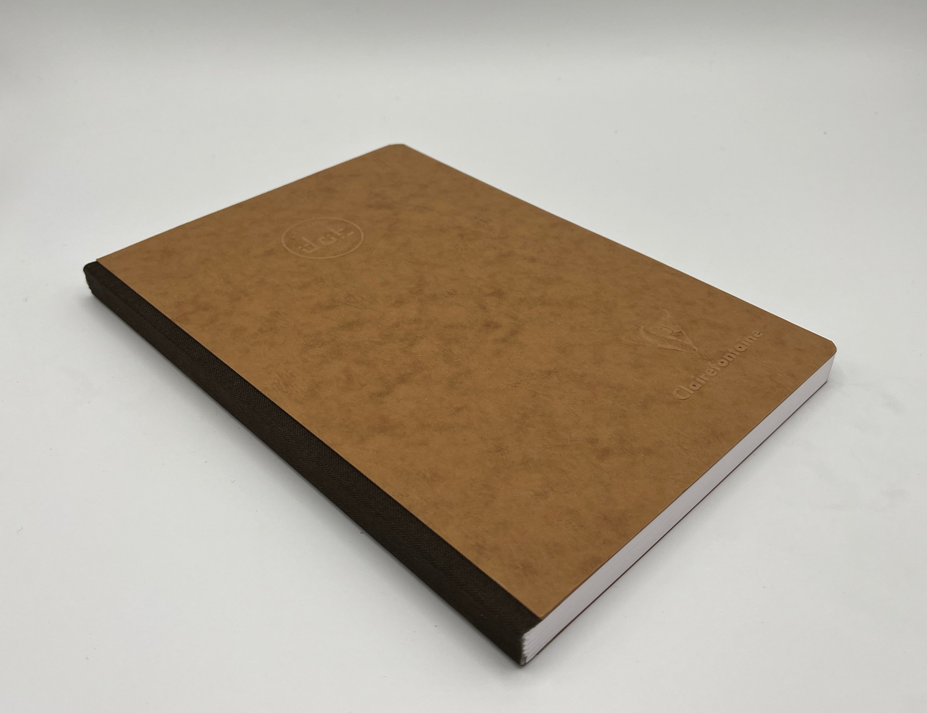 Brown notebook with black binding on a white background