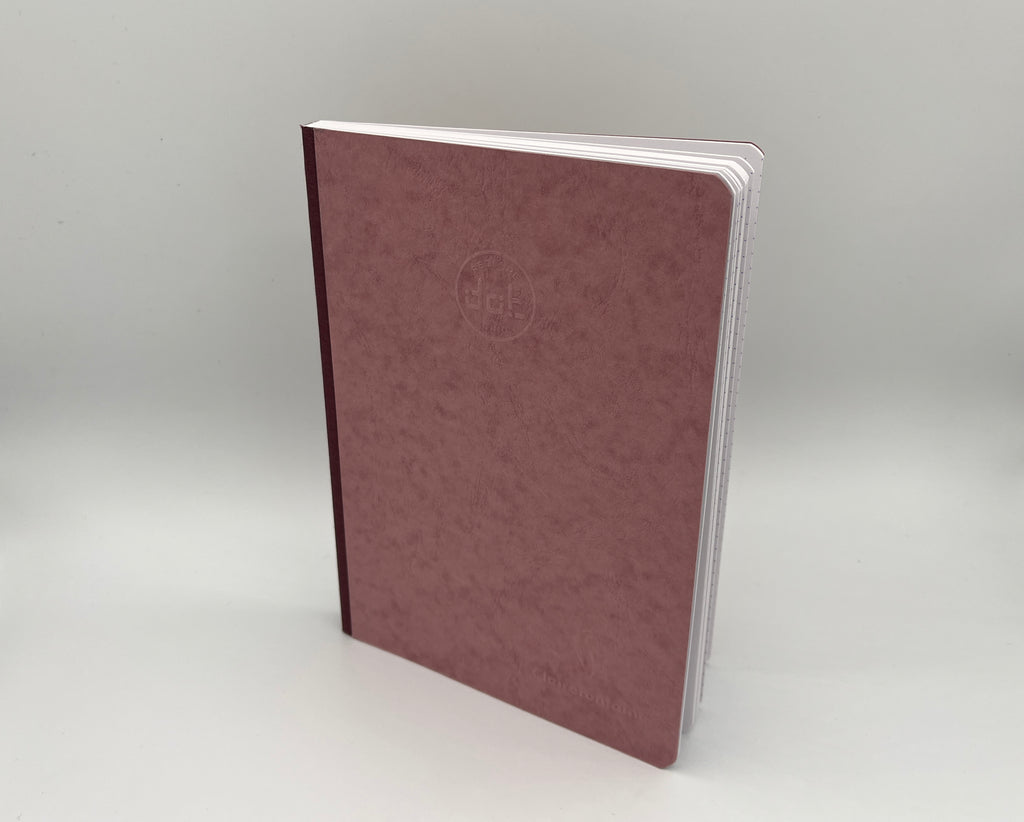 Maroon notebook with a logo on a light gray background