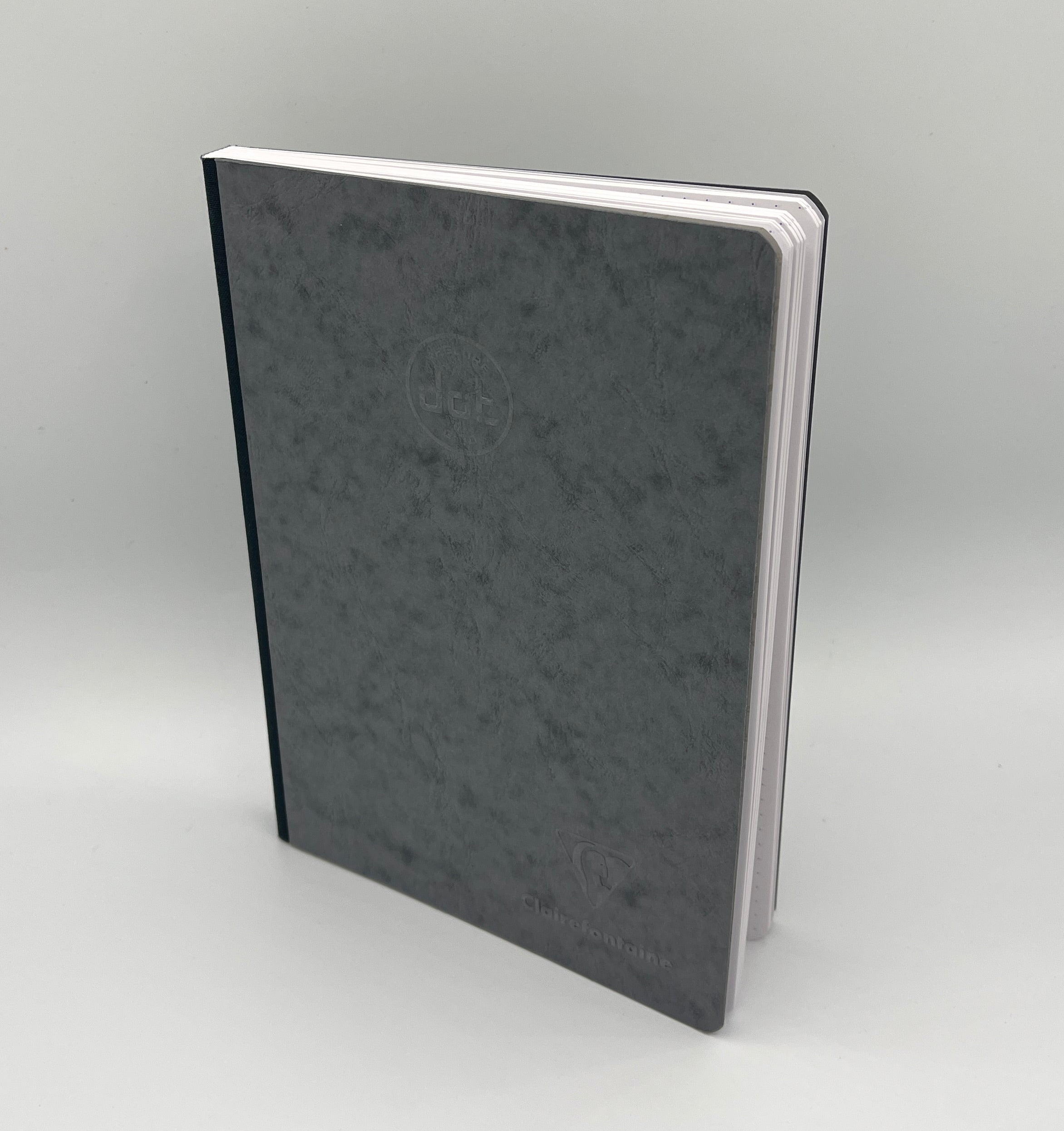 Gray notebook with a brand logo on a light gray background