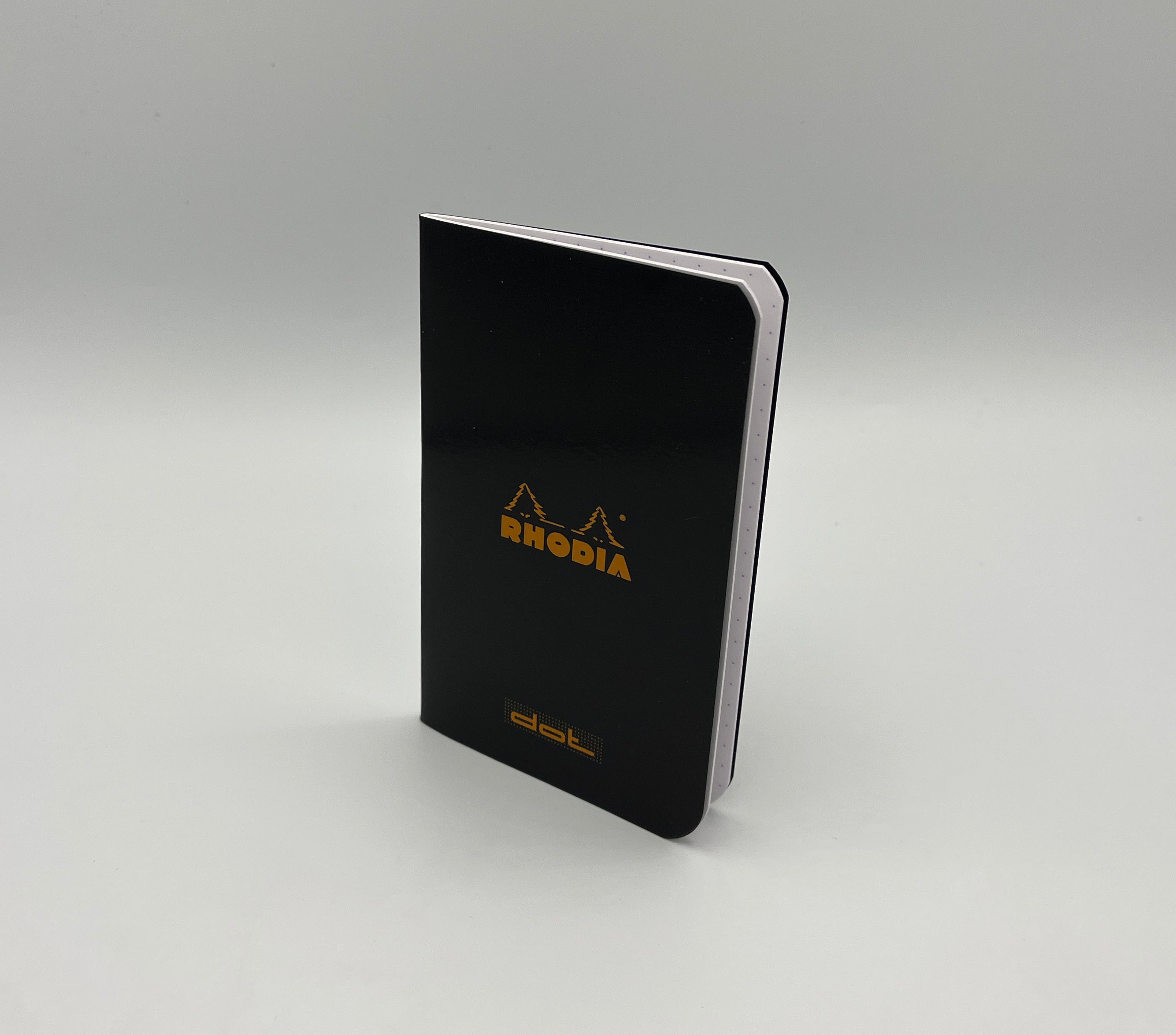 Black Rhodia notebook on a gray background